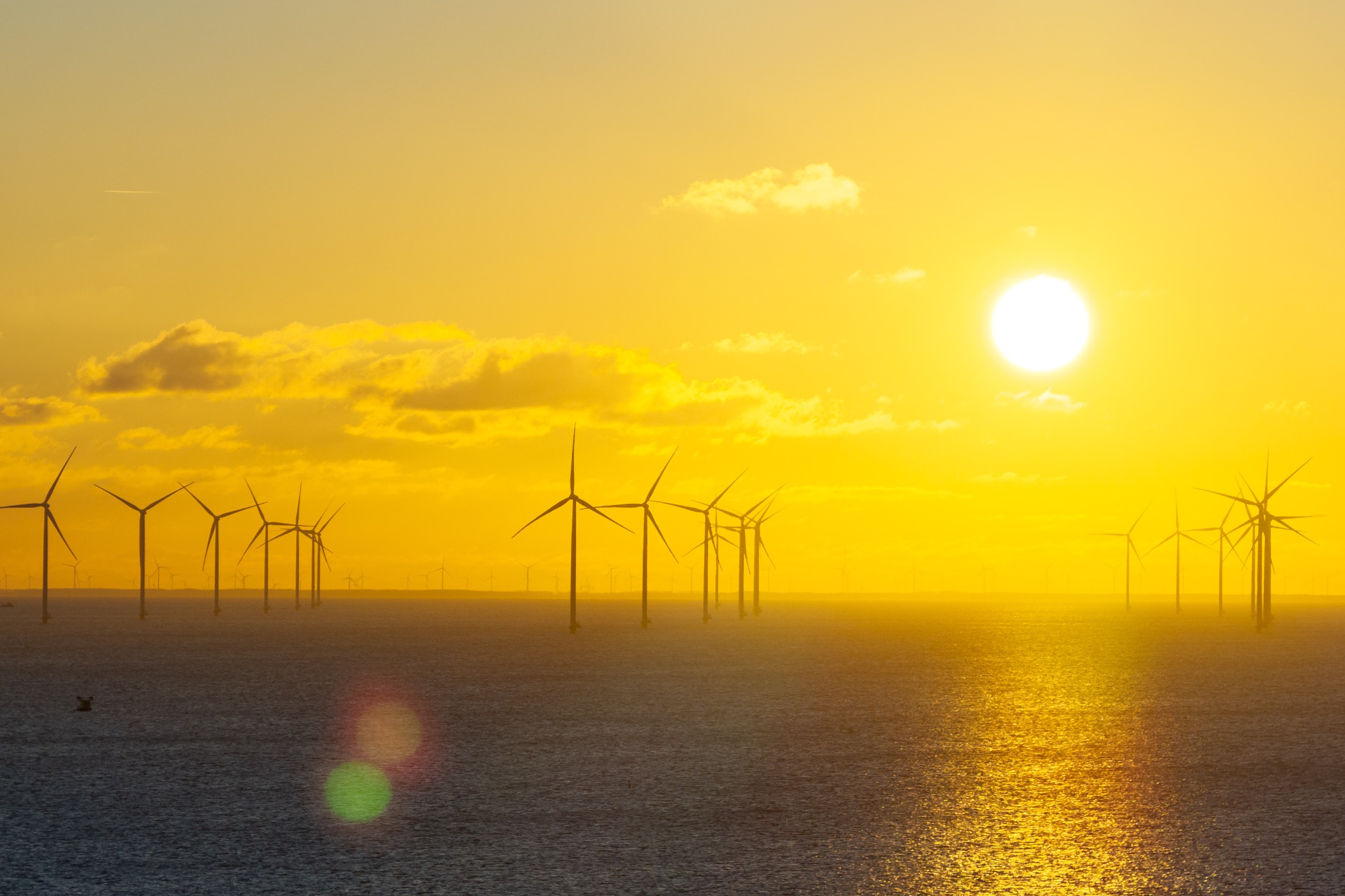 Windmolens op zee bij zonsondergang