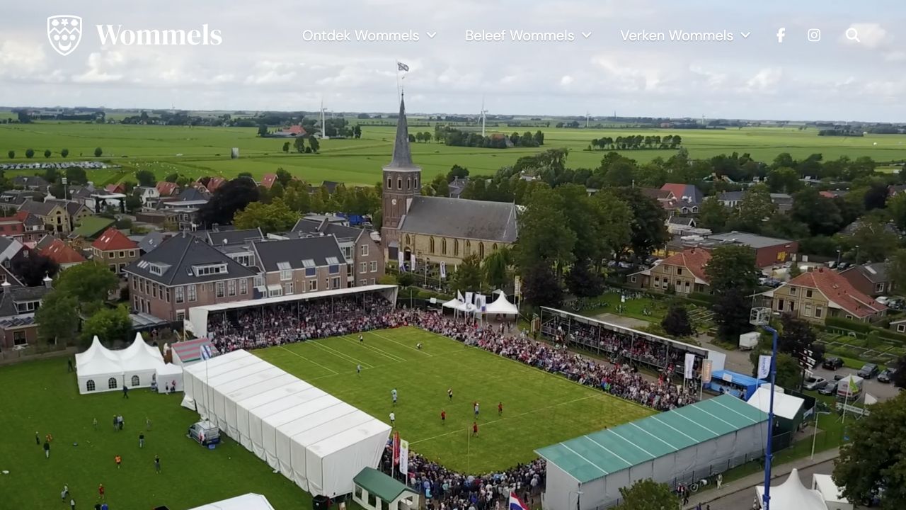 Website Wommels.nl met een luchtbeeld van het keatsveld, de kerk en het dorp in de opening